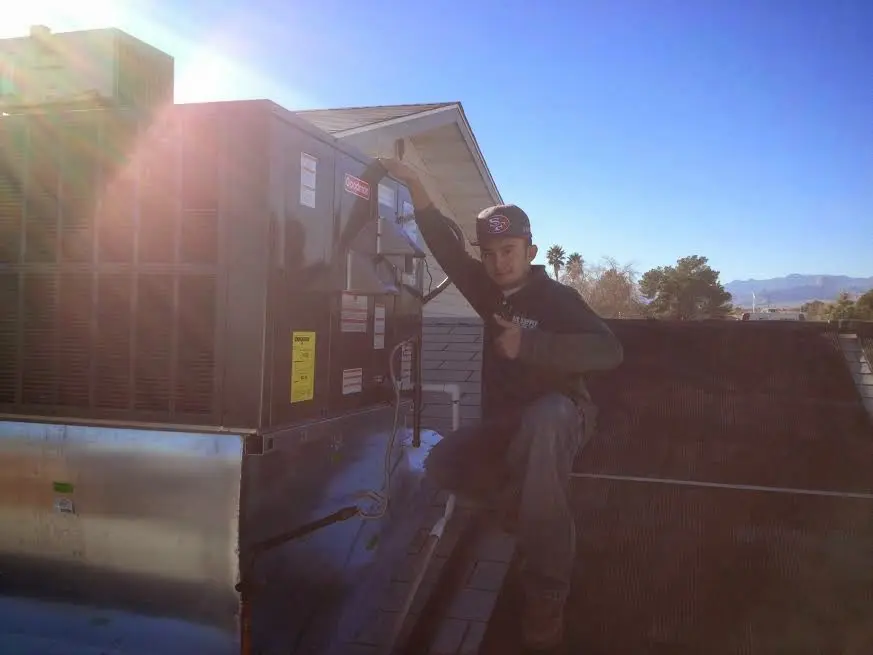 HVAC technician performing AC Tune-Up on a rooftop unit in Frankfort